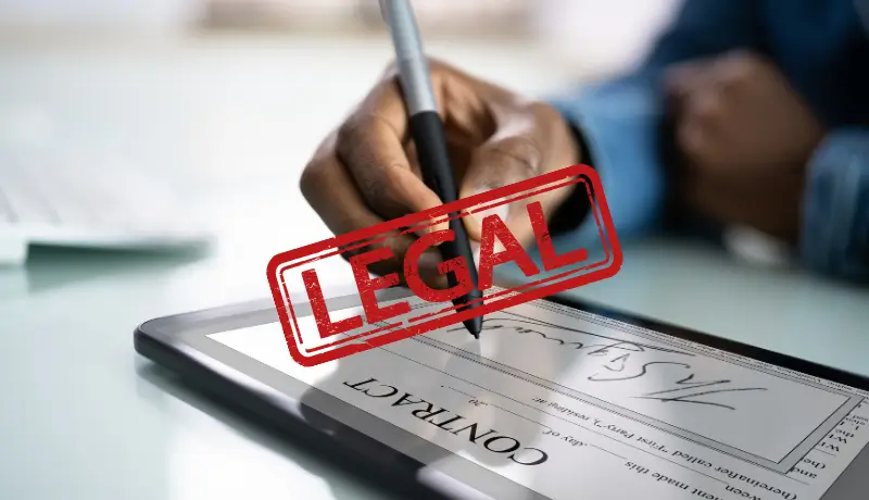 Man esigning contract with a stamp "Legal" on the photo