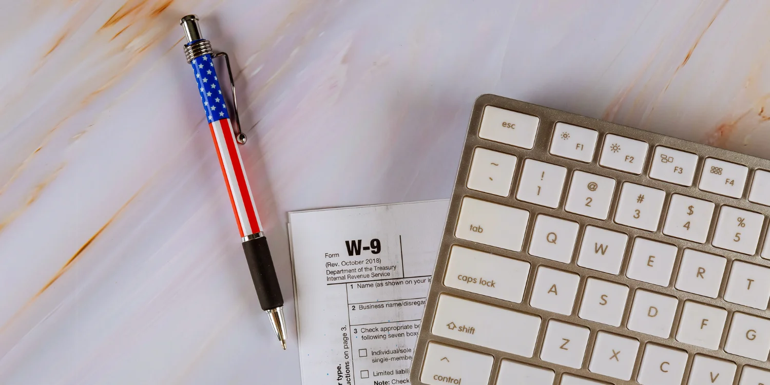 W-9 form with a keyboard and a pen on a table