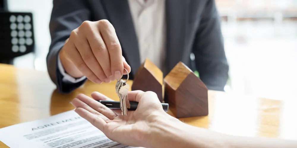 The real estate agent hands over the key to the house