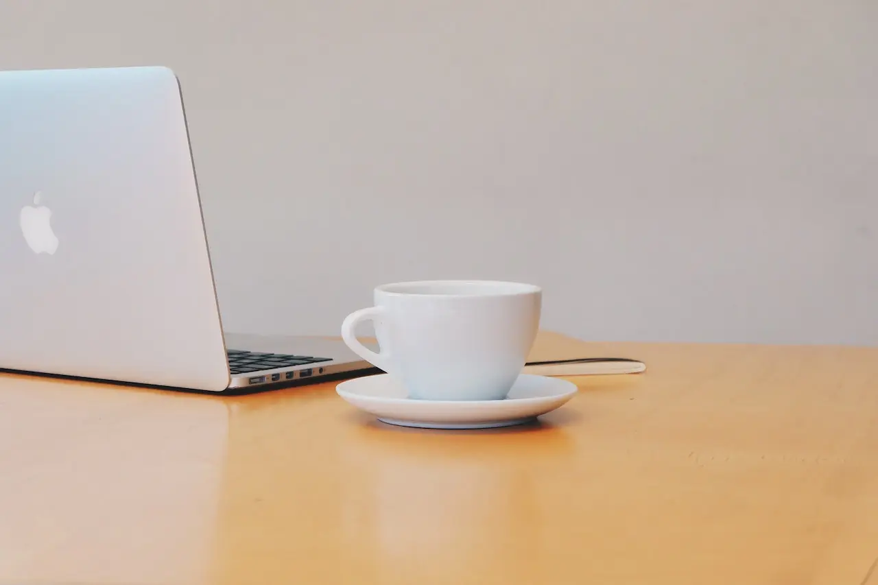 laptop and a cup of coffee on a table