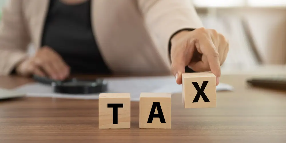 a man holds a cube with the inscription tax