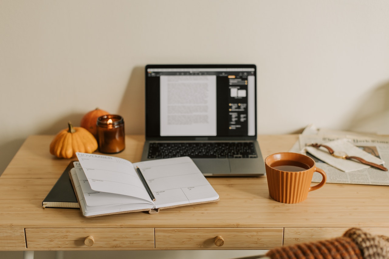 worktable with a laptop and notebook